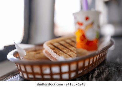 Close-up photo of a sandwich served with beverage on a basket in food truck - Powered by Shutterstock