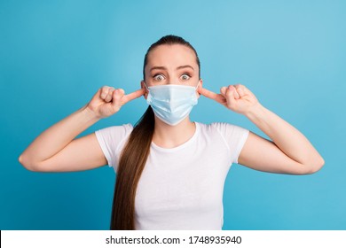 Closeup photo of scared lady hospital examination fingers inside ears big eyes not listen doctor bad diagnosis wear protect face medical mask white t-shirt isolated blue color background