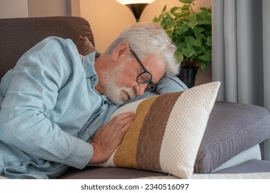 Closeup photo of sleeping senior man with white beard, peaceful grandfather resting on sofa at home, enjoying midday nap in living room. Seniors lifestyle concept - Powered by Shutterstock