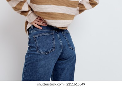 A Close-up Photo Of Stylish Jeans From Behind On A Woman Holding Her Hand Near The Pocket