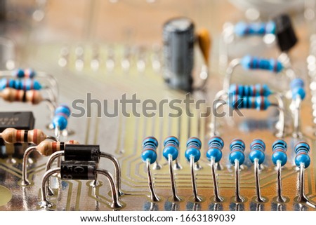 Closeup photo of technical equipment electronic board with microchip, various resistors and capacitors