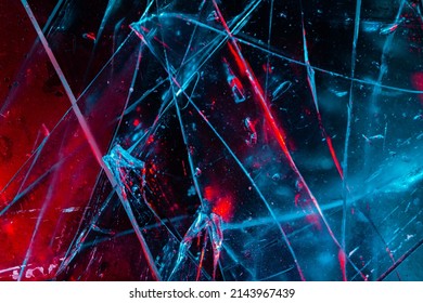 Close-up photo texture of blue and red toned broken and cracked glass on black backdrop. - Shutterstock ID 2143967439