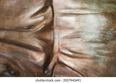 Close-up Photo Texture Of Copper Or Bronze Statue Material With Vertical Folds.