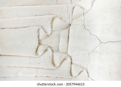 Close-up Photo Texture Of Worn And Cracked Marble Wall With Cloth Ornament.