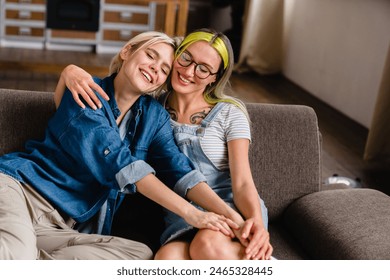 Closeup photo of two girlfriends lesbian lgbtq couple hugging cuddling spending time together at home relaxing on the sofa. Togetherness, passion, love and care - Powered by Shutterstock