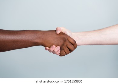 Closeup photo of two hands arms handshake different race multinational friends antiracism issue help together world globe partners relationship immigration isolated grey color background