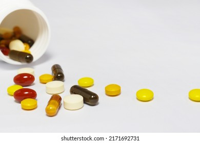 Close-up Photo Of Vitamins And Supplements On White Background With A White Bottle. Including Multi Vitamins, Vitamin B, Vitamin C, Vitamin D, Collagen Tablets, Probiotics Capsules And Iron Capsules.