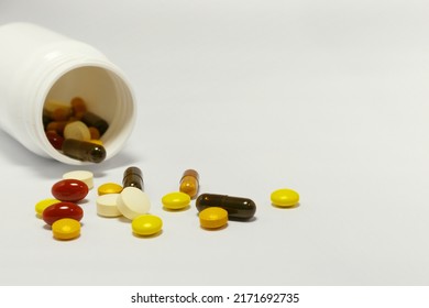 Close-up Photo Of Vitamins And Supplements On White Background With A White Bottle. Including Multi Vitamins, Vitamin B, Vitamin C, Vitamin D, Collagen Tablets, Probiotics Capsules And Iron Capsules.