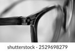 Closeup photo of wayfare shape black frame glasses, with bright white background, sharp and detailed texture, Thick glasses frame, plastic glasses frame, closeup of glasses detail with its reflection