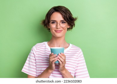 Closeup photo of young adorable attractive cute girl hold cup of coffee wear glasses smart businesswoman looking you isolated on green color background