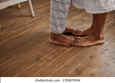 Close-up Photo Of Young African Couple Feet On The Floor, Tender Man And Woman Kissing In The Morning, In Love