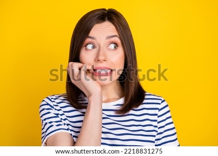 Closeup photo of young attractive woman bite teeth nervous want shoes discount uncertain look empty space isolated on yellow color background