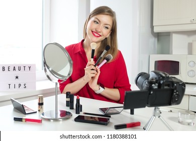 Closeup Photo Of Young Beautiful European Lady Making Video Tutorial With Beauty Tips, Reviewing Different Brushes For Makeup That She Is Holding In Hands, Sharing Professional Opinion With Viewers