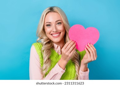 Closeup photo of young blonde girl hold her pink postcard love shape heart valentine day celebration isolated on blue color background - Shutterstock ID 2311311623