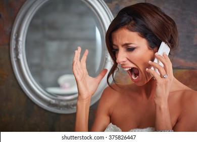 Closeup photo of young bride shouting on mobilephone.
