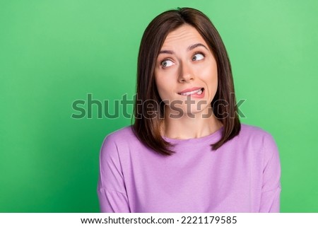 Closeup photo of young funny attractive lady bite lips oops mistake looking empty space isolated on green color background