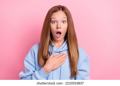 Closeup Photo Of Young Funny Excited Shocked Little Schoolgirl Wear Blue Hoodie Touch Chest Reaction Open Mouth Grimace Isolated On Pink Color Background