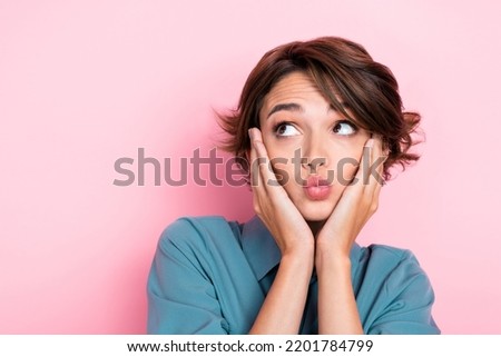Closeup photo of young pretty adorable gorgeous nice girl hold hands cheeks pouted lips minded interested look empty space ad isolated on pink color background