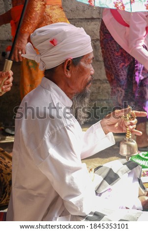 Closeup photograph of a Balinese Hindu high priest conducting a Ngaben ceremony in Ubud, Denpasar, Bali, Indonesia.