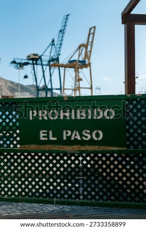 A close-up photograph captures a weathered, rectangular green metal sign with the phrase 