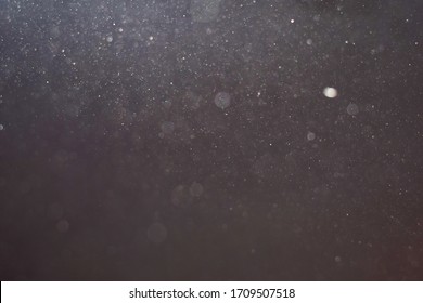 Close-up photograph of dust particles floating in a dust mote, perfect for backgrounds or textures.