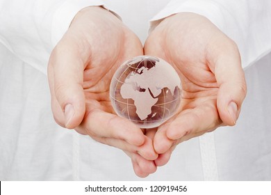 Close-up Photograph Of A Glass Globe In Man's Hands.