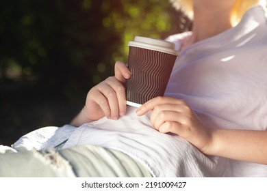 Closeup Photography Of Anonymous Woman, Holding Craft Paper Cup With Coffee Outside.