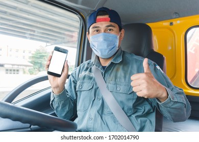 Close-up Photos Of Asian Truck Drivers Wearing Masks To Protect Against Dust And The Spread Of The Flu. Covid 19. Inside The Car Front.He Is Using A Smartphone To Communicate.White Screen Smartphone