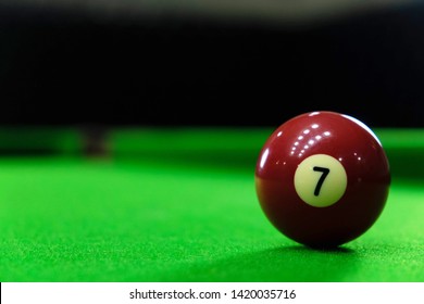 Close-up photos of billiard ball, number 7 and green floor.