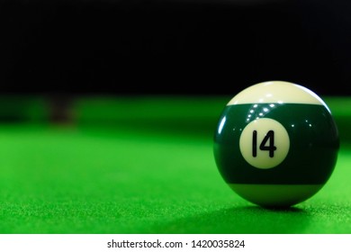 Close-up photos of billiard ball, number 14 and green floor. - Powered by Shutterstock