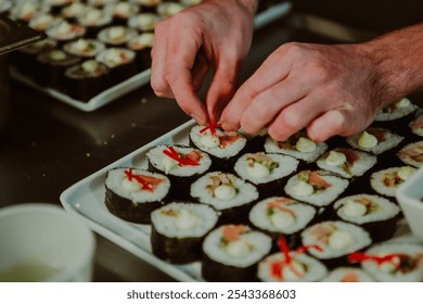 Close-up photos of a chef garnishing freshly made Sushi - entrée dishes being plated for serving to the guests - Powered by Shutterstock