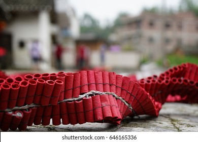 Closeup photos of a red rocket firecrackers were places on the ground with the blurred background of Chinese home.