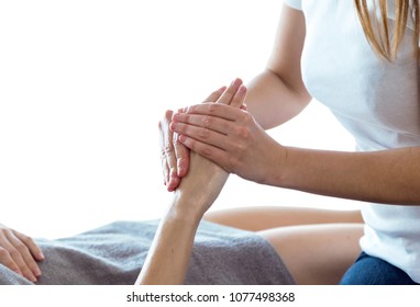 Close-up of physiotherapist pressing specific spots on female palm. - Powered by Shutterstock