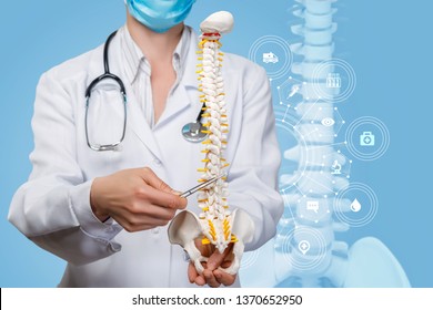 A closeup of a physiotherapist with a stethoscope examining a spine model at the digital spine image and medical structure scheme background. - Powered by Shutterstock