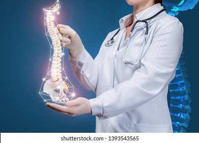 A closeup of a physiotherapist with a stethoscope operating with a spine model with pelvis element with at dark background with digital spine image. A concept of spine diseases treatment.