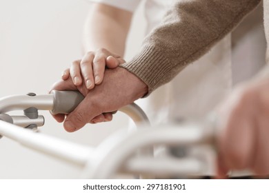 Close-up of physiotherapist supporting disabled senior man - Powered by Shutterstock