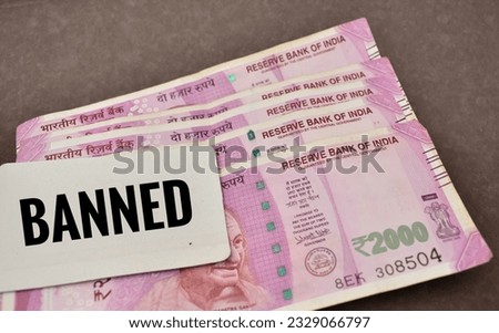 A closeup Picture of Banned Indian two thousand rupees bank currency notes with Text Banned on card.