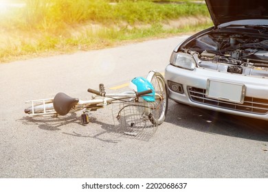 Closeup Picture Of A Car Crashes Into A White Bicycle On Road With Sun Flare.