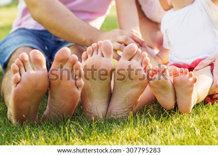 Closeup picture of family feets lying in line at green grass