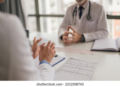 Closeup Picture Of Female Medical Worker, Discussing The Symptoms With Her Mentor At The Hospital.