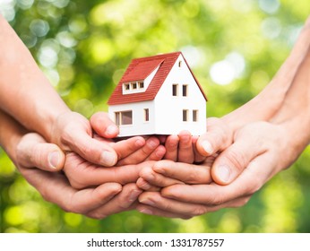 closeup picture of hands holding the house - Shutterstock ID 1331787557