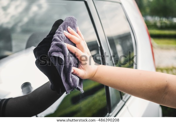 Closeup picture, image young woman, driver,\
dry wiping her car with microfiber cloth after washing it, cleaning\
auto, automobile windows. Transportation self service, care\
concept. Paint\
protection
