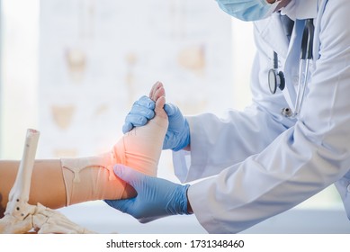 Close-up of pictures of a male orthopedic doctor or orthopedic doctor Wear a medical mask and medical gloves. Going to analyze the cause of ankle bone degeneration In his office at the hospital - Shutterstock ID 1731348460