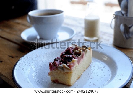 Closeup of a piece of cheesecake and cup of coffee on a wooden table