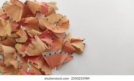 A close-up of a pile of colorful pencil shavings scattered on a white background, showcasing creativity and art. - Powered by Shutterstock