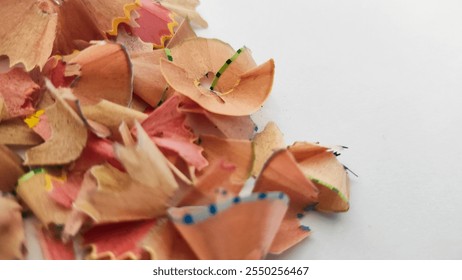 A close-up of a pile of colorful pencil shavings scattered on a white background, showcasing creativity and art. - Powered by Shutterstock