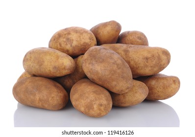 Closeup of a pile of russet potatoes on a white surface with reflection. - Shutterstock ID 119416126