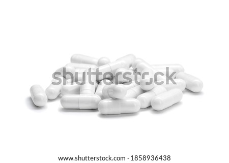 Close-up of a pile of white colored pills or capsules on isolated white background. Selective Focus.