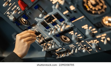 Close-up of a pilot's hand turning a toggle switch on the control panel.