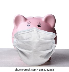 Closeup Of A Pink Piggy Bank Wearing A COVID-19 Surgical Mask.